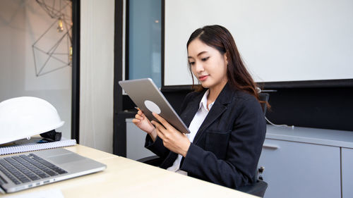 Young woman using mobile phone while sitting at home