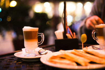 Close-up of coffee latte in cup by food on table