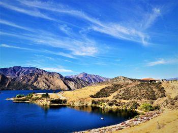 Scenic view of lake and mountains against blue sky