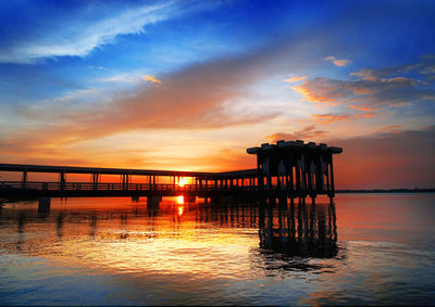 Pier over sea against sky during sunset