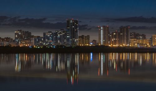 Reflection of illuminated buildings in lake at night