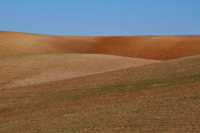 Scenic view of desert against clear blue sky