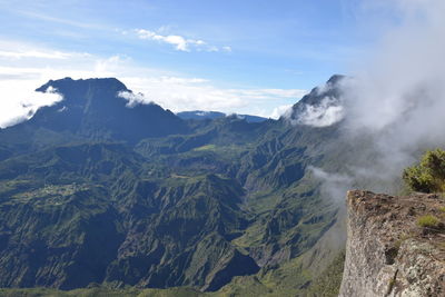 Scenic view of mountain range against cloudy sky