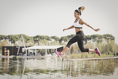 Woman jumping by water