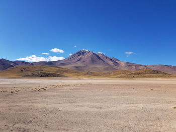 Scenic view of arid landscape against clear blue sky