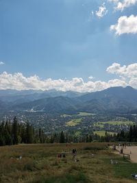 Scenic view of field and mountains against sky