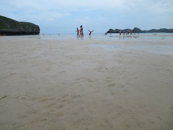 People on beach against sky