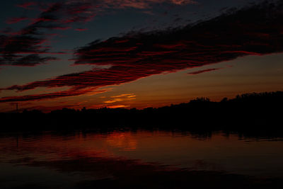 Scenic view of dramatic sky over lake during sunset