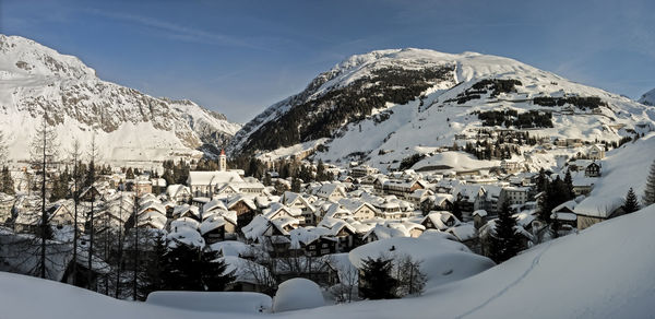 Snow covered houses and buildings against sky