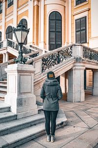 Rear view of woman standing against building