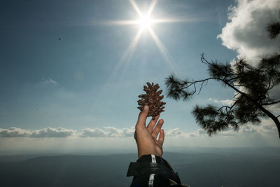 Low section of man standing on mountain against sky