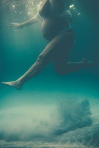 Low section of pregnant woman swimming in sea