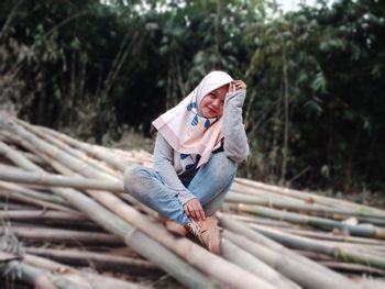 Man sitting on log in forest