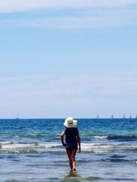 Rear view of woman standing on beach