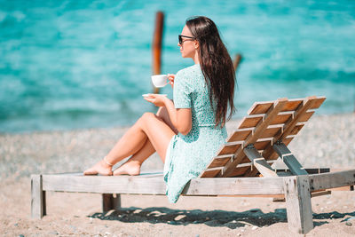 Young woman sitting on bench at seat