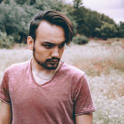 Portrait of young man standing on field