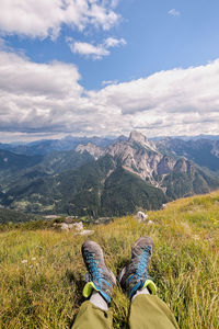 Low section of person on mountain against sky