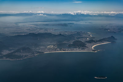 Aerial view of sea and mountains against sky