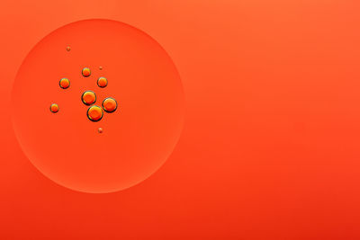 Close-up of bubbles over water against orange background