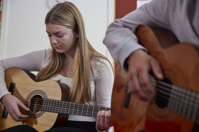 Teenagers attending guitar lesson