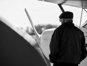 Rear view of man standing by airplane