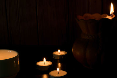 Close-up of lit candle in the dark