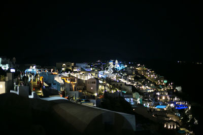 High angle view of illuminated town against sky at night