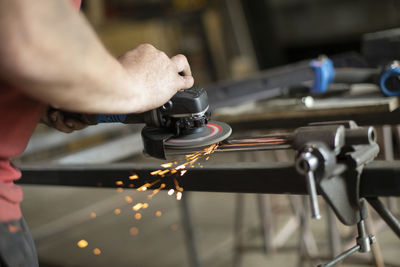 Metal grinding. steel processing with power tools. a man is working on a part in the garage. 