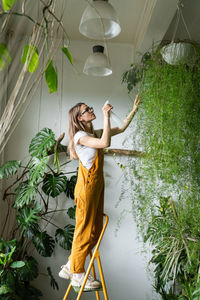 Woman watering plantings in workshop