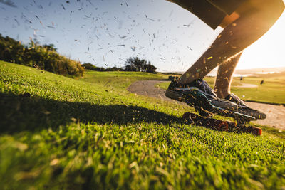 Low section of man skateboarding on field