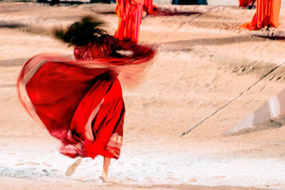 Full length of woman dancing on sand at night