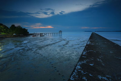 Pier over sea against sky during sunset