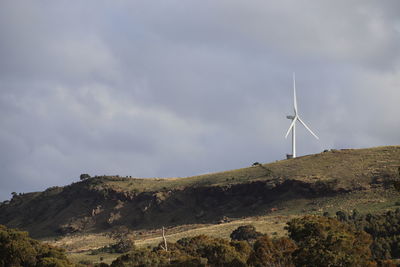 Wind turbines on land against sky