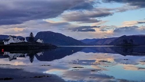 Scenic view of lake by mountains against sky