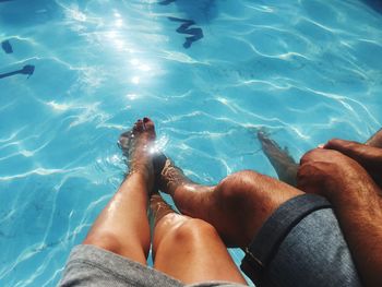 Low section of woman sitting in swimming pool