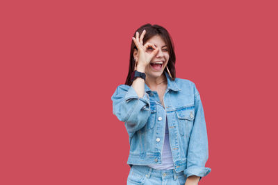 Smiling young woman against red background