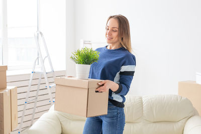 Young woman smiling while holding camera in box