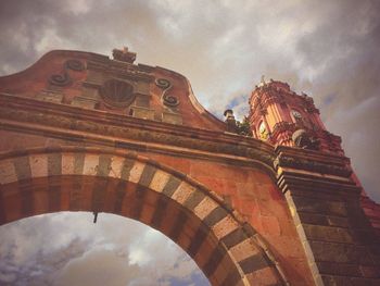 Low angle view of building against cloudy sky