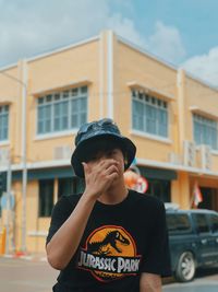 Portrait of teenage boy standing against built structure