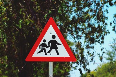 Road sign against trees