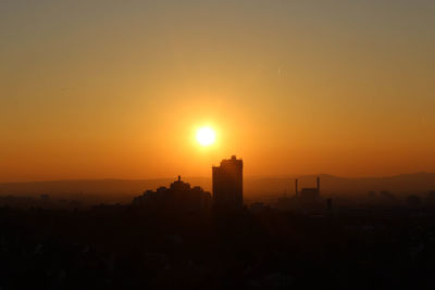 Silhouette cityscape against sky during sunset