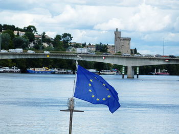 Sailboat on river against sky in city