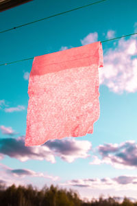 Low angle view of pink umbrella against sky