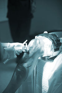 Close-up of doctor injecting syringe in patient knee in operating room