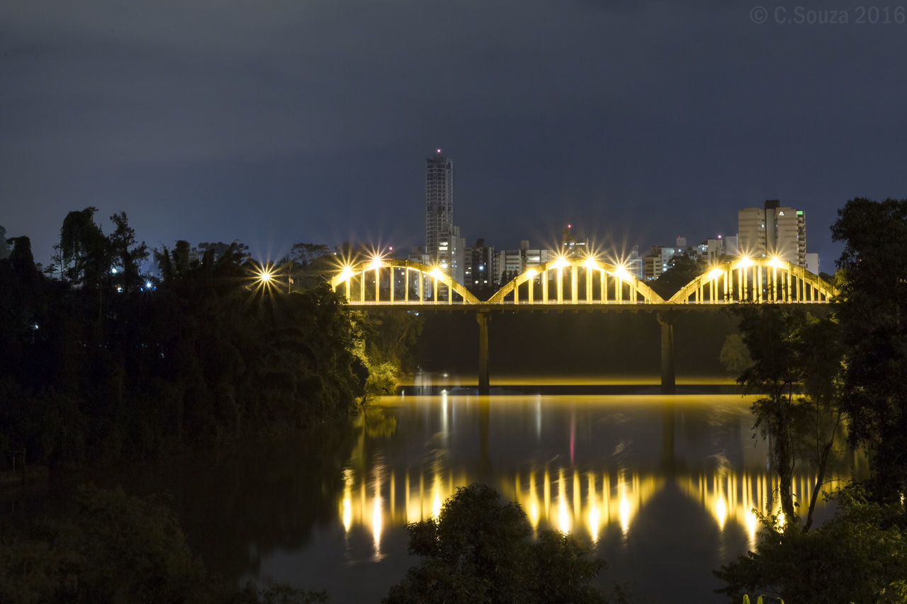 REFLECTION OF ILLUMINATED BUILT STRUCTURE IN WATER