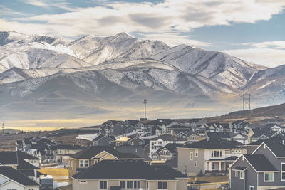 Aerial view of townscape and mountains against sky