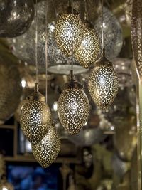 Low angle view of illuminated pendant lights hanging on ceiling