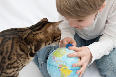 Full length of a boy holding cat