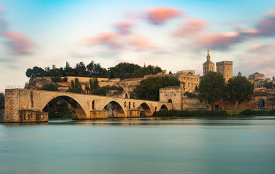 Arch bridge over river against buildings