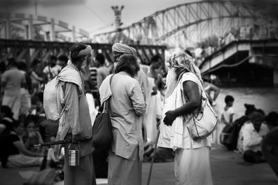 Rear view of people walking on street in city